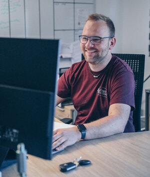 Mitarbeiter fröhlich am PC im Büro von Stellrecht Elektrotechnik